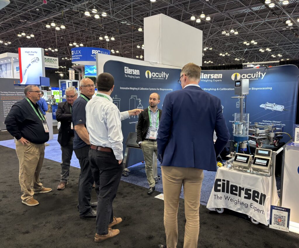 Acuity Process Solutions team members speaking with attendees at the INTERPHEX 2026 exhibition booth alongside Eilersen process weighing technologies.